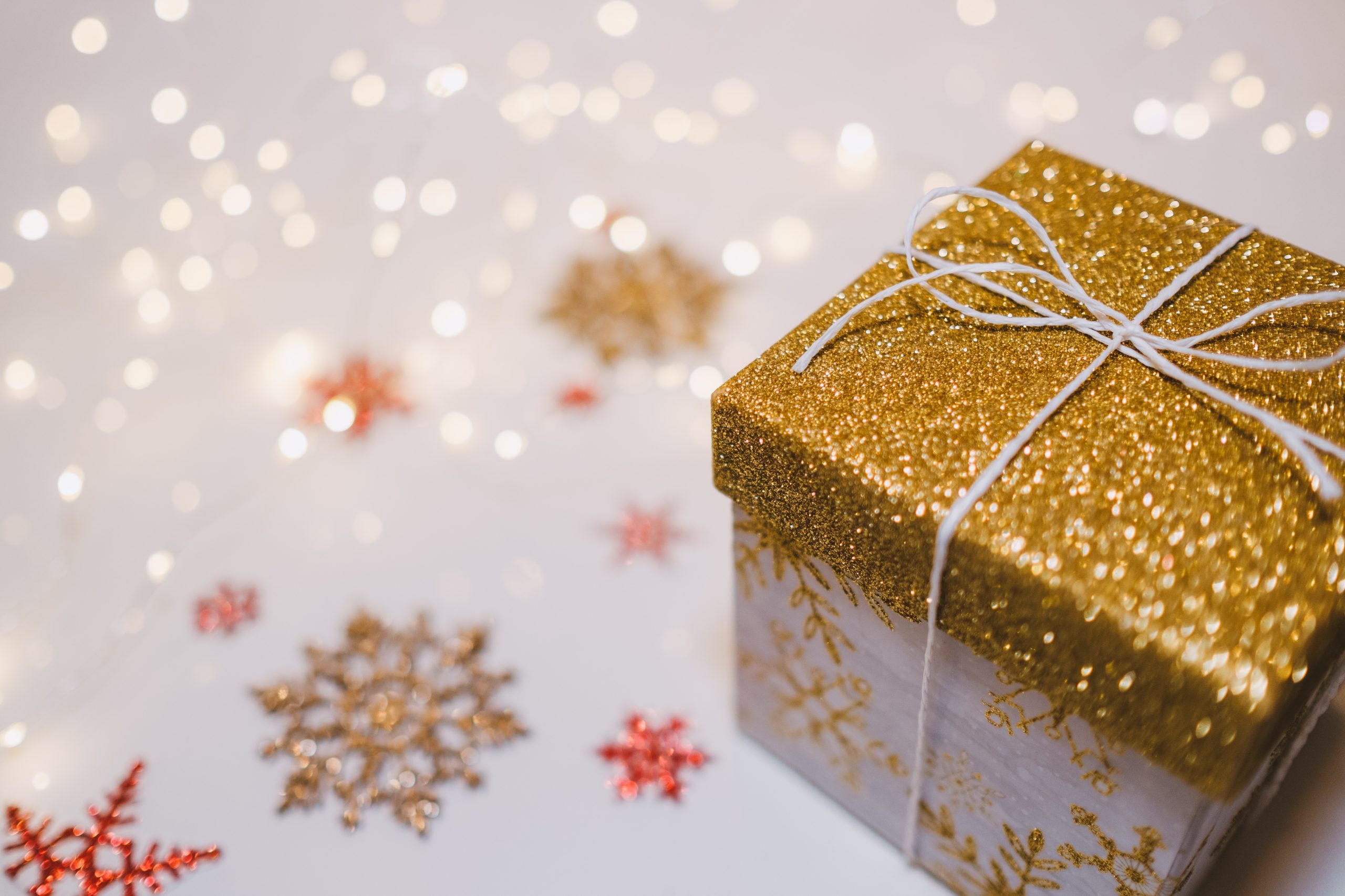 present with gold glittery top sitting on red and gold snowflakes