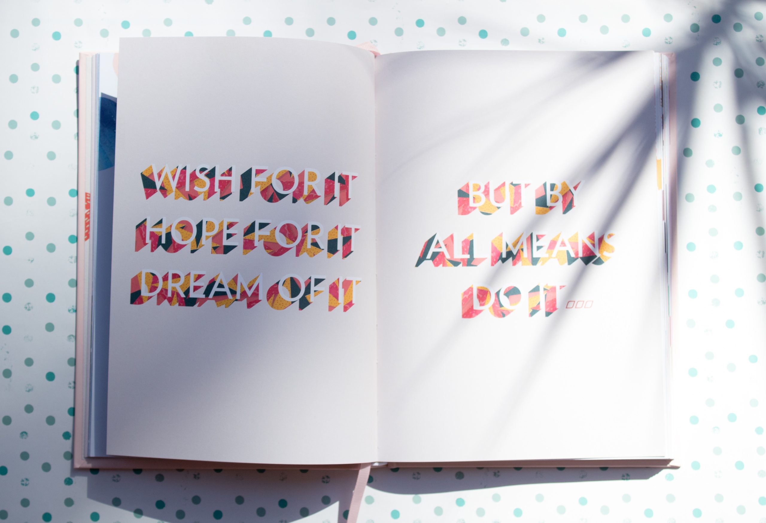 open book with wish for it hope for it dream of it by by all means do it text on the pages